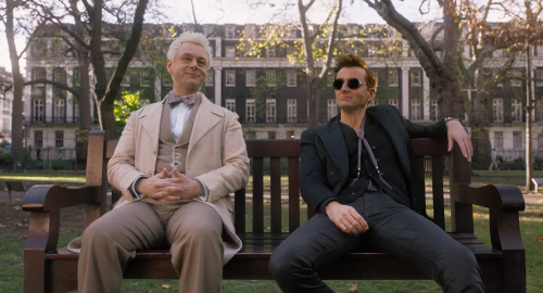 Aziraphale and Crowley, sitting on a park bench. Aziraphale wears a creamy tan suit, and sports a cheery smile. Crowley, all in black, is slouched, man-spreading, and scowling a bit.